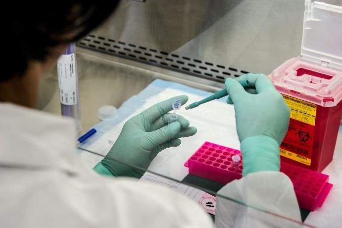 A scientist using pipettes to isolate genetic material